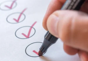 Main tenant un stylo et cochant des cases sur un document