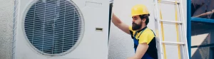 Personne révisant une pompe à chaleur